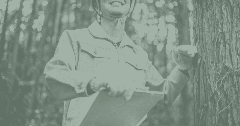 A man with a clipboard stands at a tree