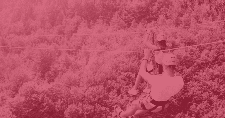 A man records a woman ziplining over a forest